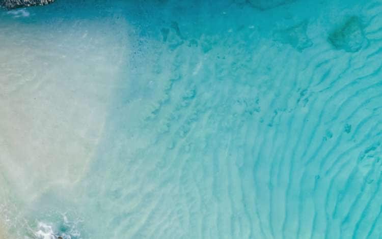 a couple of men and women on the beach of Tres Trap Aruba Caribbean Island. Tres Trapi Bay is popular with locals for snorkeling and diving in the turqouse colored ocean