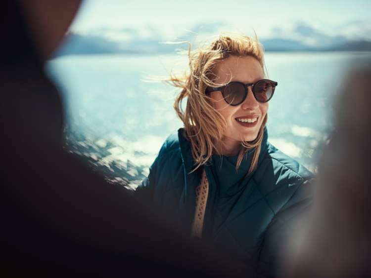 A woman in sunglasses looks at the Alaskan scenery on the deck of Queen Elizabeth