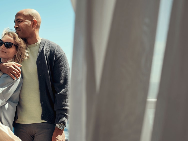 Two people standing on a cruise ship balcony enjoying an ocean view