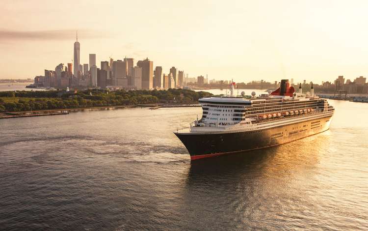 Queen Mary 2 sails out of New York city at sunrise