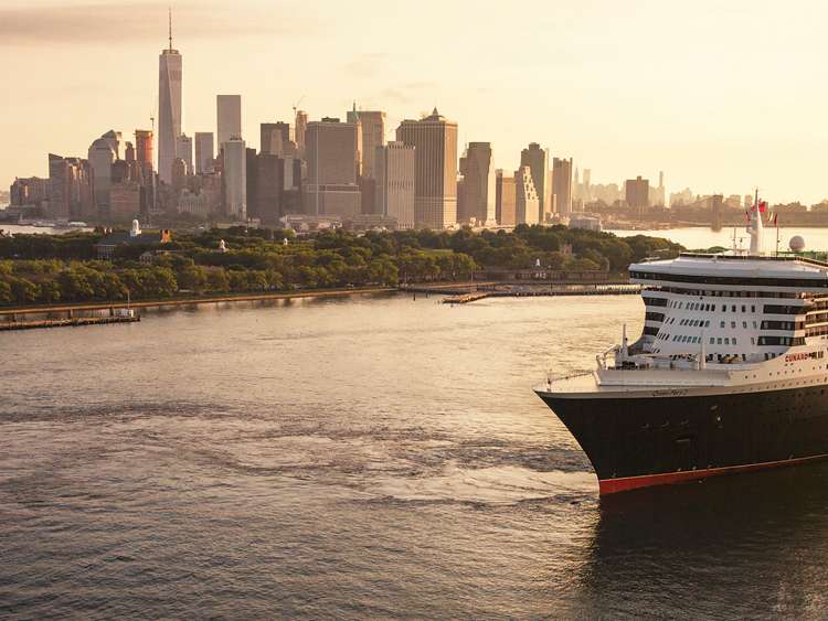 Queen Mary 2 sails out of New York city at sunrise