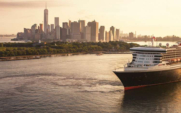 Queen Mary 2 sails out of New York city at sunrise