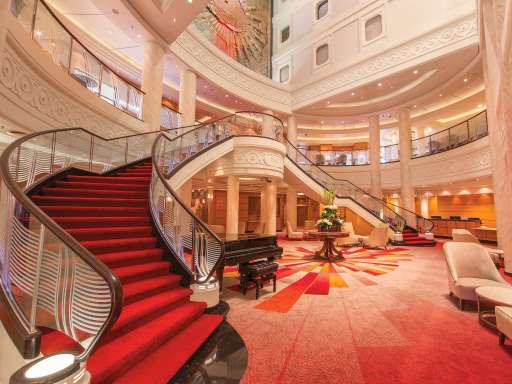 Queen mary 2's Grand Lobby with sweeping staircase, purser's desk, and shops above