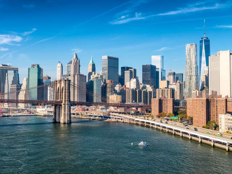 A view of Manhattan from the Hudson River, with Brooklyn Bridge in the foreground