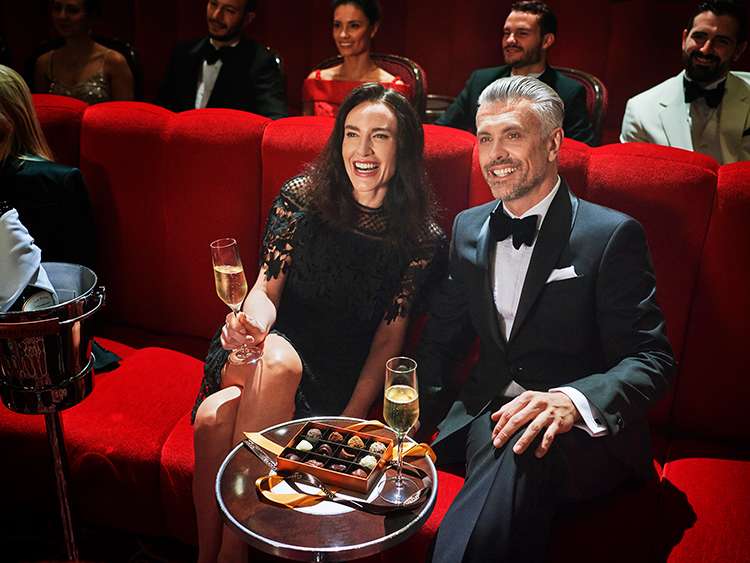 Couple in the Royal Court Theater, enjoying the show with champagne and chocolates