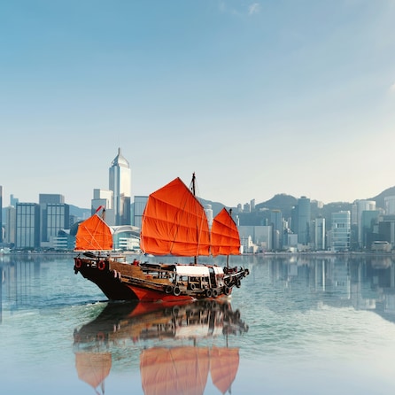Red junk boat crossing Hong Kong harbor