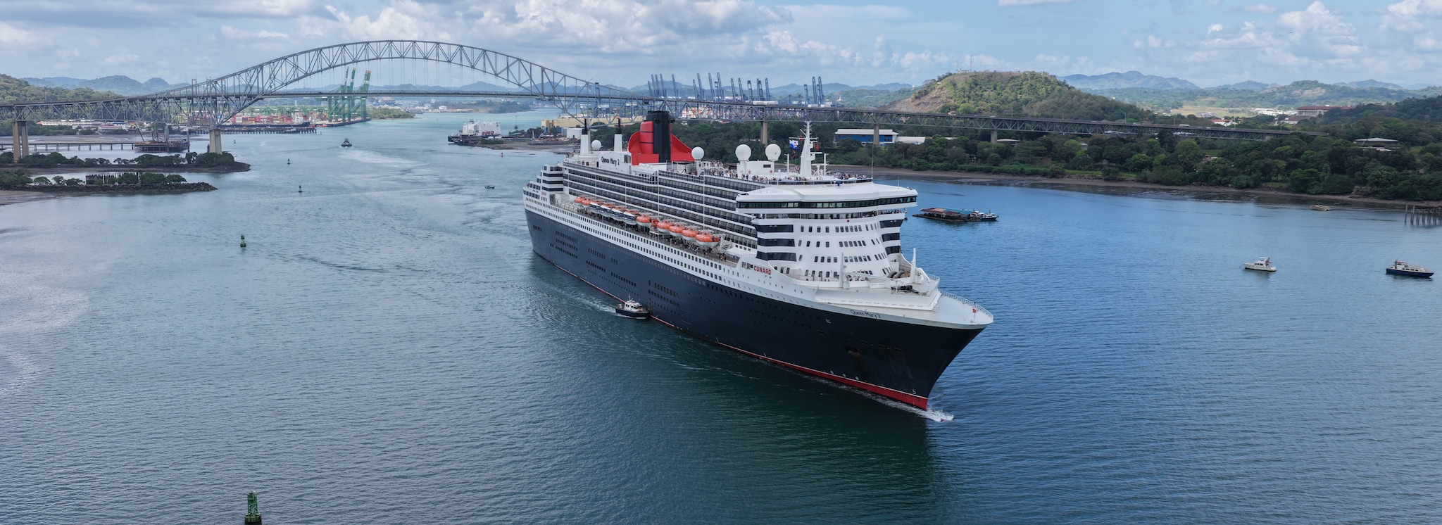 {"metadata_en_US":{"alt-text":"Side view of Queen Mary 2 sailing through the Panama Canal"}}