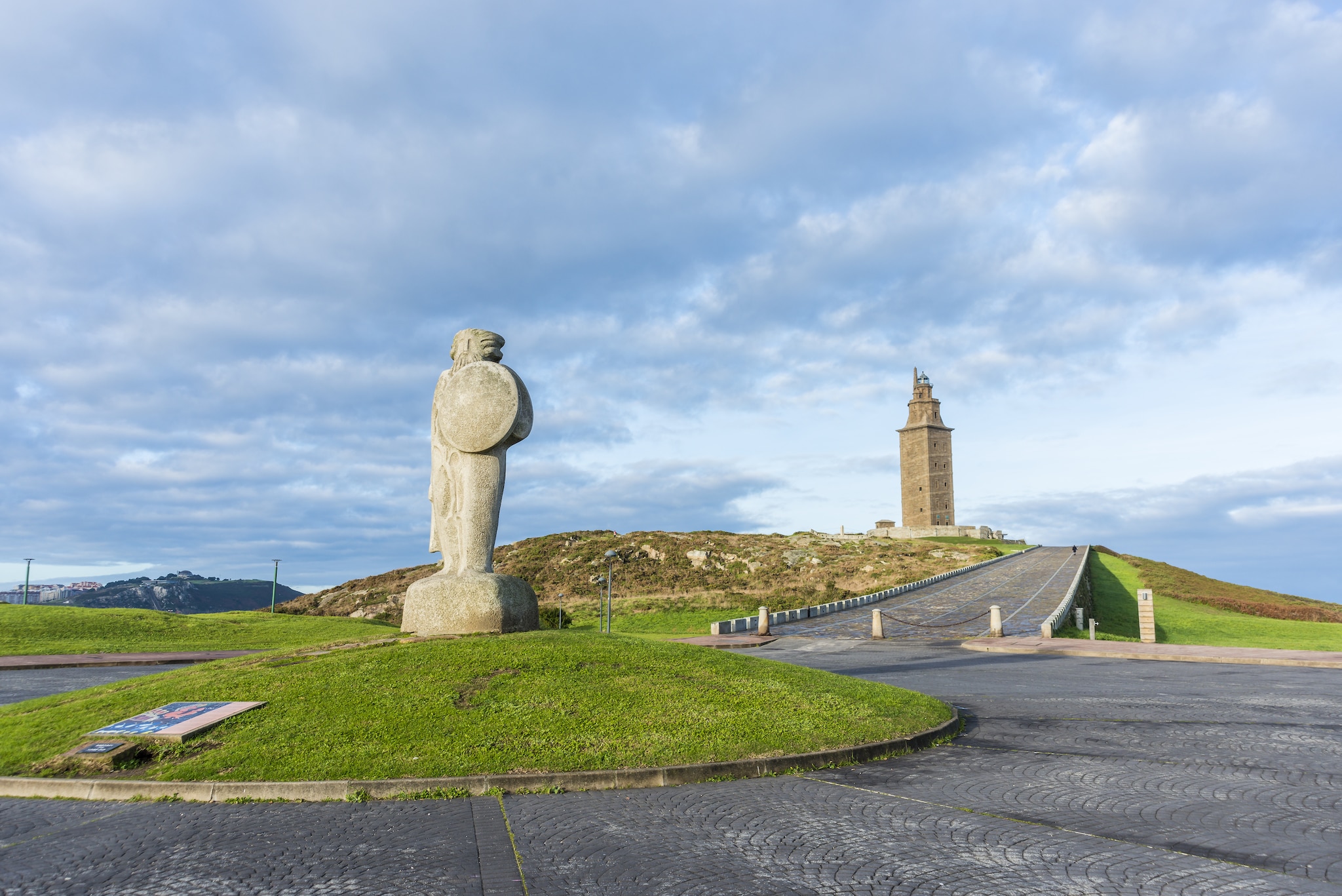 {"metadata_en_GB":{"alt-text":"This image shows the Tower of Hercules and the statue of Breogán in A Coruña, Galicia, Spain."},"metadata_de_DE":{"alt-text":"Dieses Bild zeigt den Herkulesturm und die Statue von Breogán in A Coruña, Galicien, Spanien."},"metadata_en_AU":{"alt-text":"This image shows the Tower of Hercules and the statue of Breogán in A Coruña, Galicia, Spain."},"metadata_en_US":{"alt-text":"This image shows the Tower of Hercules and the statue of Breogán in A Coruña, Galicia, Spain."}}