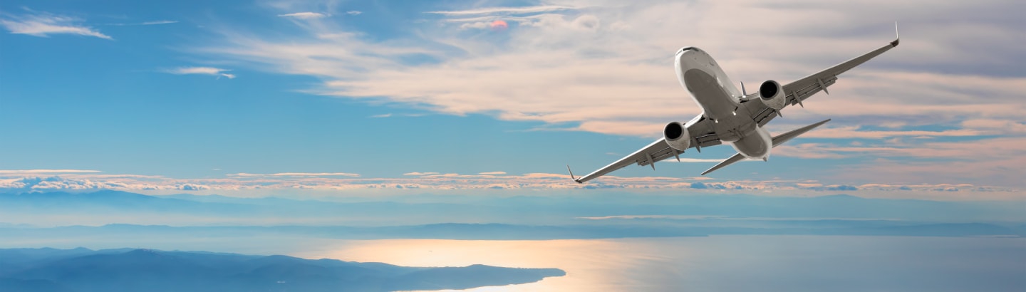 Airplane flying over tropical sea at sunset; Shutterstock ID 1888782955; purchase_order: N/A; job: Cruise images; client: Cunard_digital; other: part of digi licencing