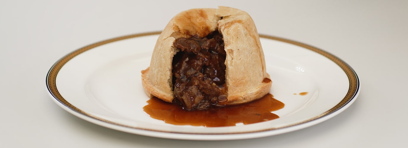 Open freshly baked steak and ale pie oozing gravy. 