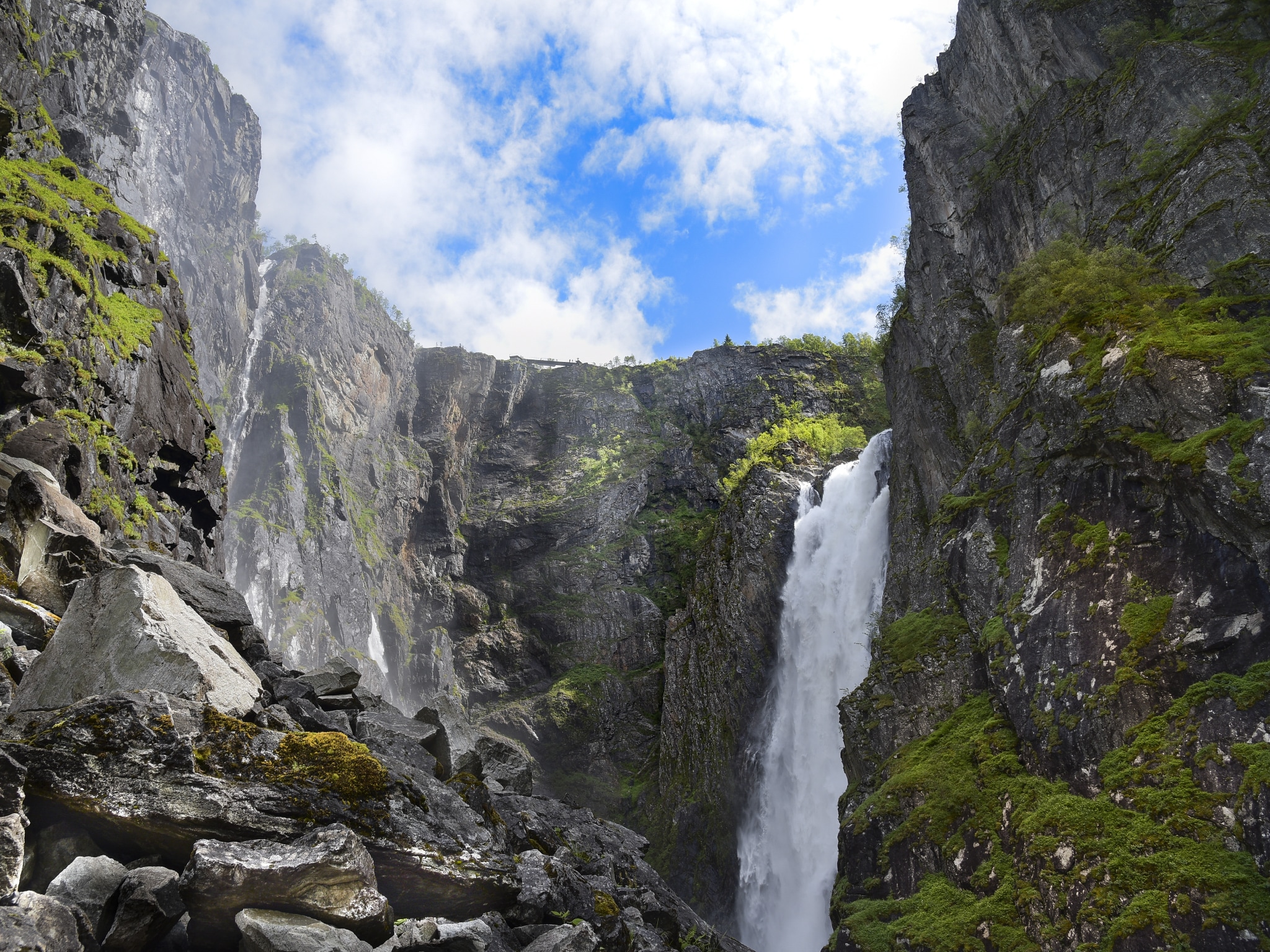Waterfall in cliffs with blue skies in the background