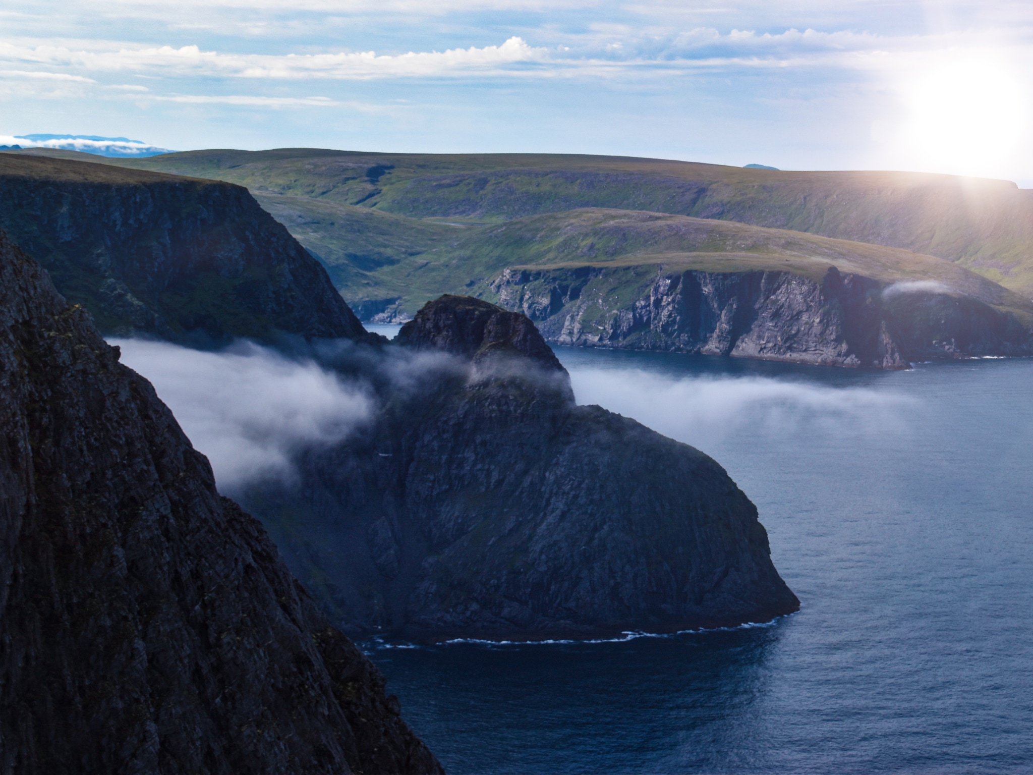 Cliffs in Norway, North Cape as the sun shines in the background