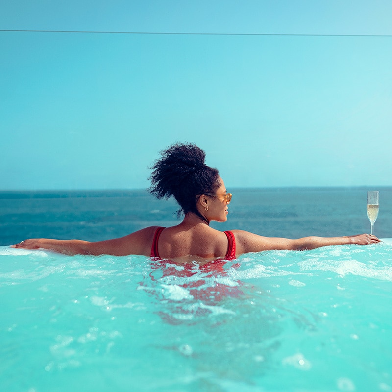 Guest enjoying a glass of champagne in a whirlpool on board Cunard cruise ship Queen Anne